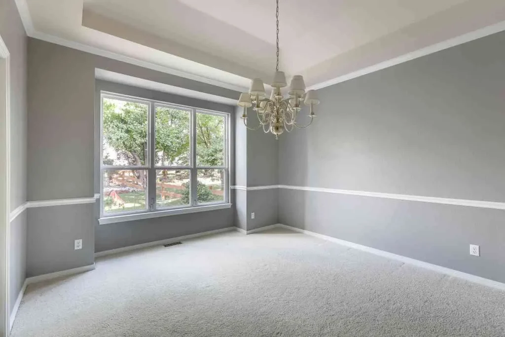Freshly painted dining room with large windows and chandelier